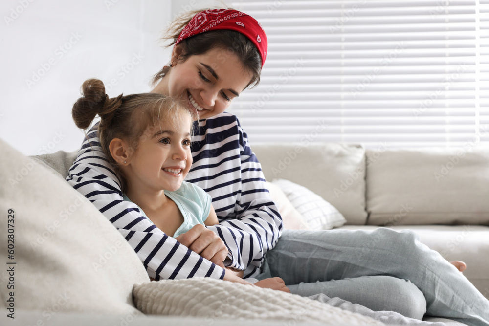 Young mother and her daughter spending time together on sofa at home Young mother and her daughter spending time together on sofa at home