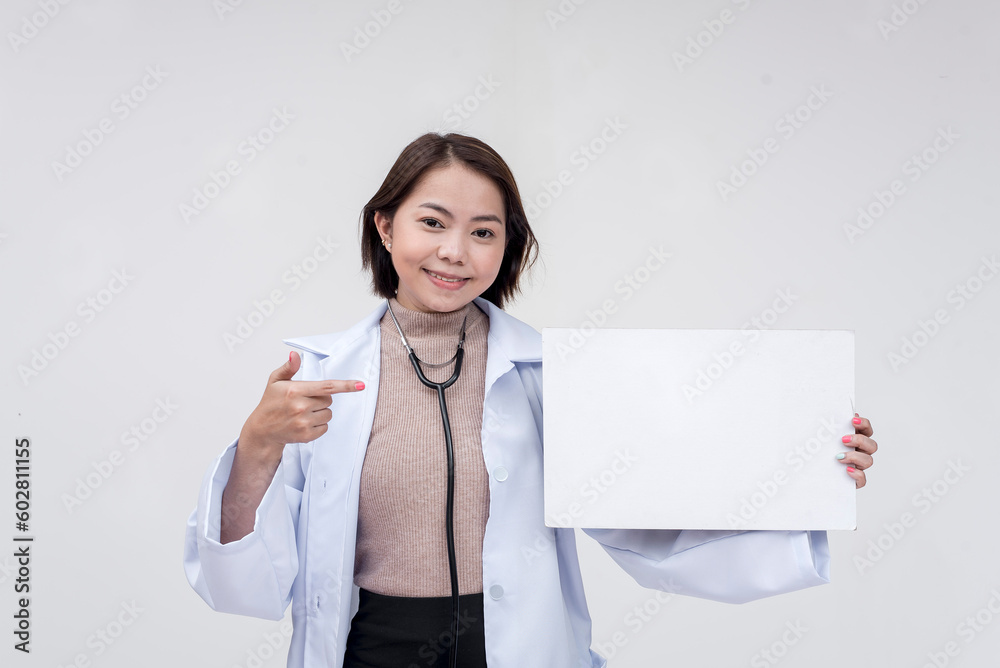Portrait of a young and skilled doctor, medical student, intern holding and pointing at a sign board. Isolated on a white background. Portrait of a young and skilled doctor, medical student, intern holding and pointing at a sign board. Isolated on a white background.