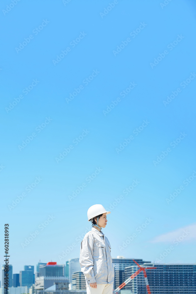 ヘルメットを装着して作業着を着た女性 ヘルメットを装着して作業着を着た女性