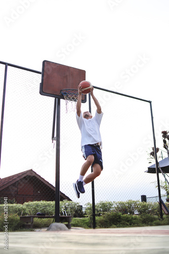 Basketball player slam dunk at the court. 