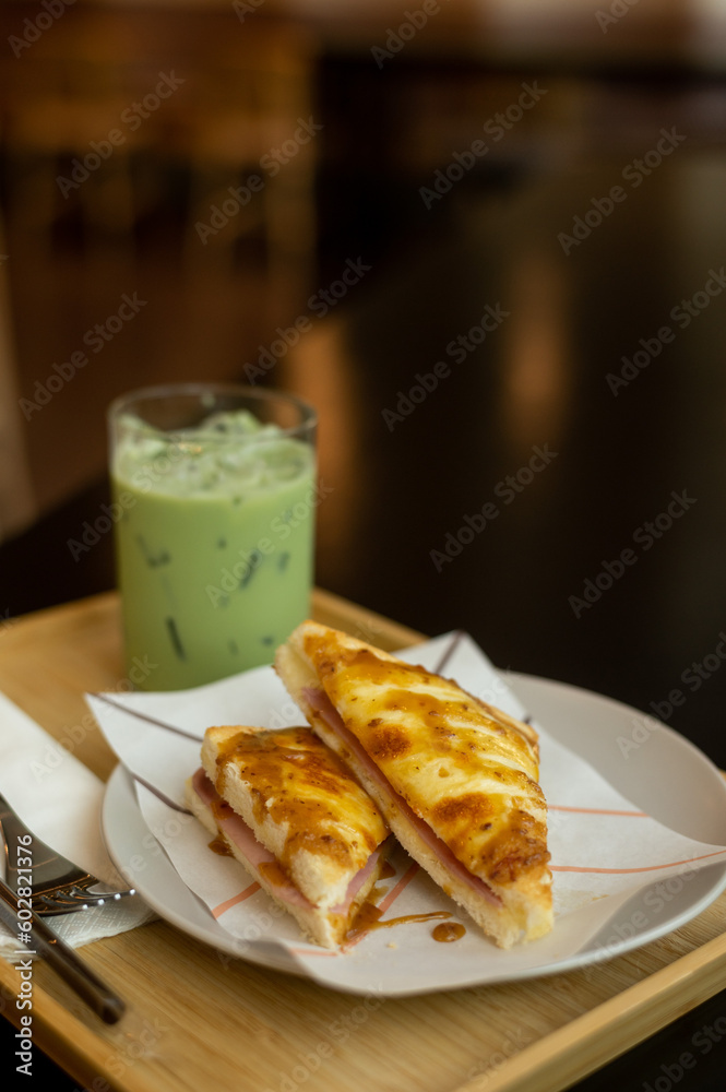 Ham and cheese sandwich on a white plate with iced green tea Ham and cheese sandwich on a white plate with iced green tea