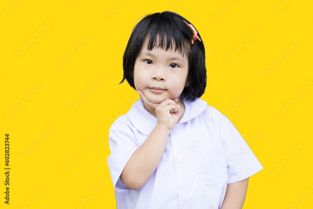 Happy smiling cute girl shows on yellow color background Happy smiling cute girl shows on yellow color background