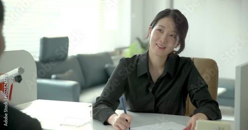 은행 직원에게 안내를 받고있는 손님