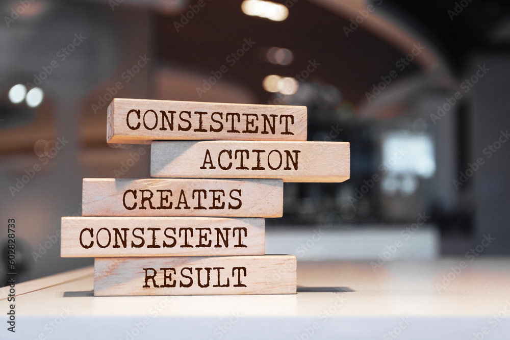 Wooden blocks with words 'Consistent action creates consistent result'.