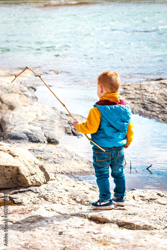 Little boy fishing in a river (back view)