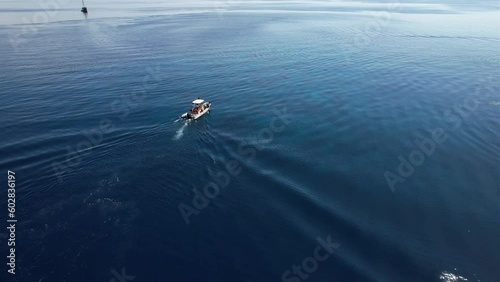 View on a dhingy with divers which just arrived to a dive spot with crystal clear waters and amazing coral reefs below them in Yangeffo, Raja Ampat, Papua, Indonesia photo