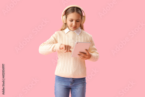 Little girl in headphones u...