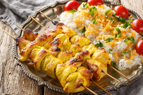 Obraz na plátne Persian Jujeh kabab is an Iranian dish that consists of grilled chunks of chicken marinated in saffron and yogurt served with rice closeup on the plate on the table