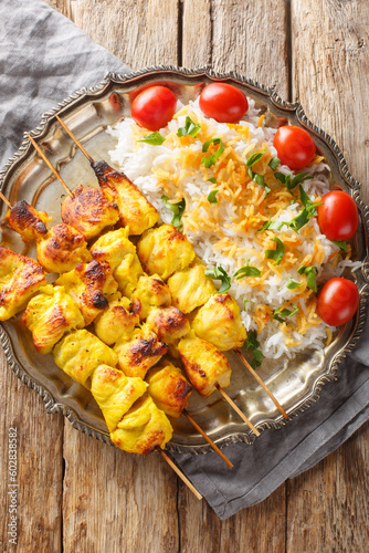 Φωτογραφία Joojeh kabab is a classic Persian chicken kebob with rice closeup on the plate on the table