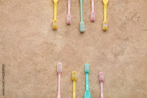 Different plastic toothbrushes on color background