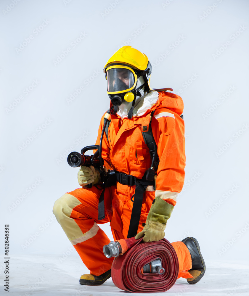 Naklejka premium On the pristine white background, a firefighter wearing a helmet and gloves kneels with purpose their grip on the fire hose showcasing their readiness to confront fires head on.