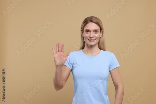 Woman giving high five on light brown background