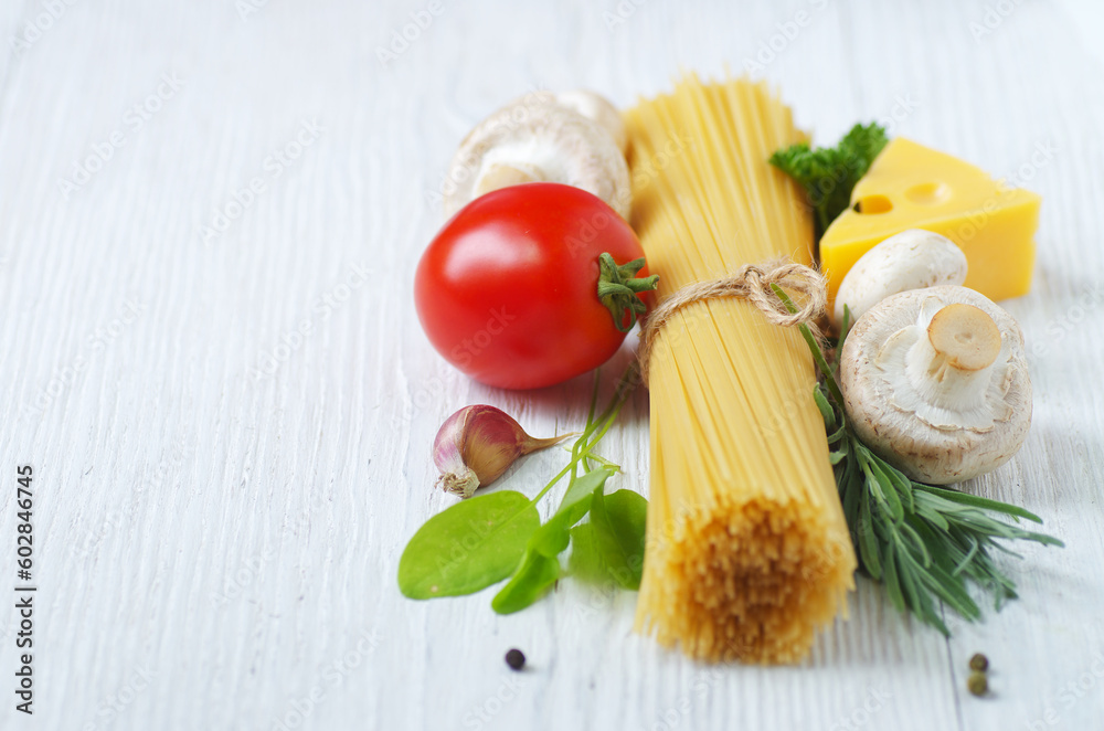 Pasta spaghetti, cheese, vegetables and spices on a white wooden table Pasta spaghetti, cheese, vegetables and spices on a white wooden table