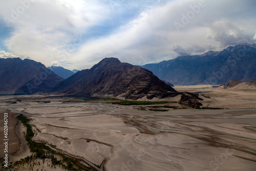 beautiful river and dune desert in the mountains, cold desert in skardu, katpana desert and indus river in the mountains valley of skardu in pakistan  photo