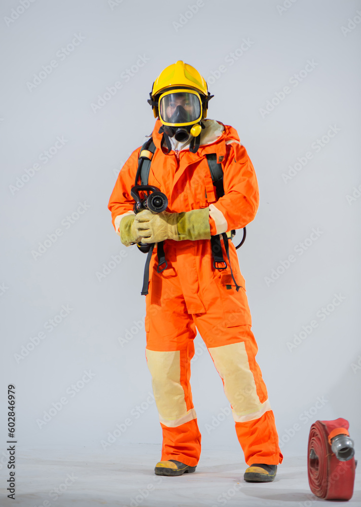 Firefighter standing and holding fire hose on white background. Firefighter standing and holding fire hose on white background.