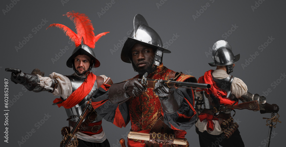 Portrait of multiethnic group of three conquistadors with steel armors and flintlock rifles. Portrait of multiethnic group of three conquistadors with steel armors and flintlock rifles.
