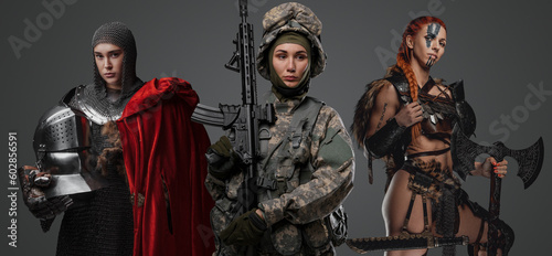 Studio shot of female soldier holding rifle with ancient amazon and knight woman.