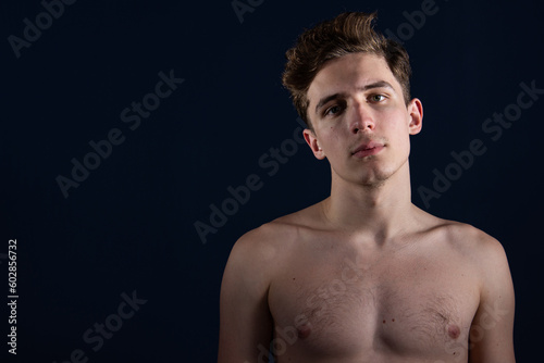 Young attractive man with athletic body posing in the studio.