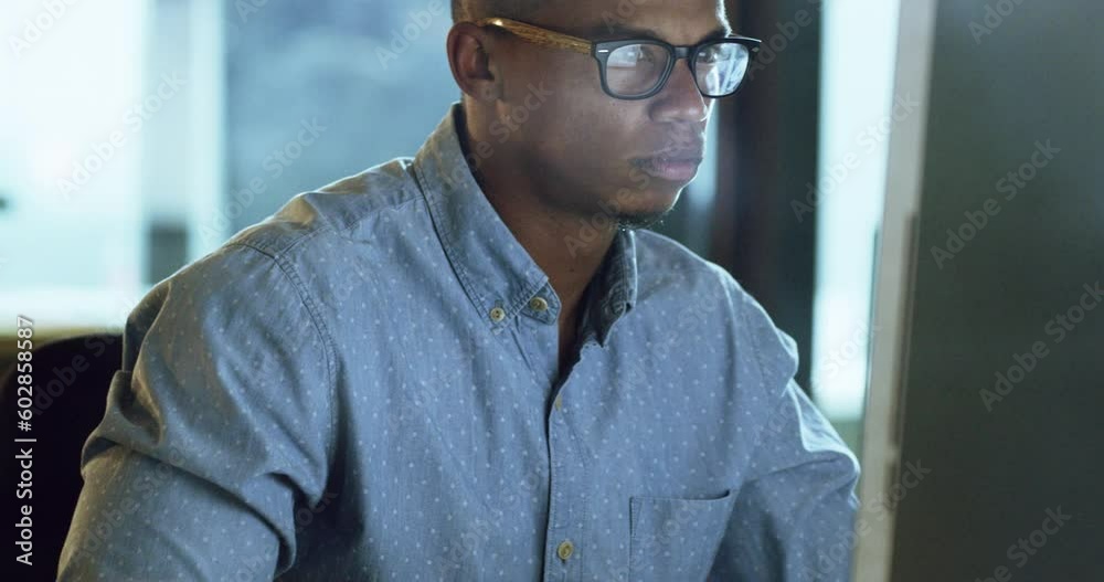 Computer, night and focus with a business man working late in his office on an overtime company project. Face, glasses and professional with a serious male employee sitting at his desk for work