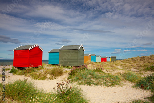 Canvas Print Colorful wooden beach huts at Findhorn beach, Moray coast, Scotl