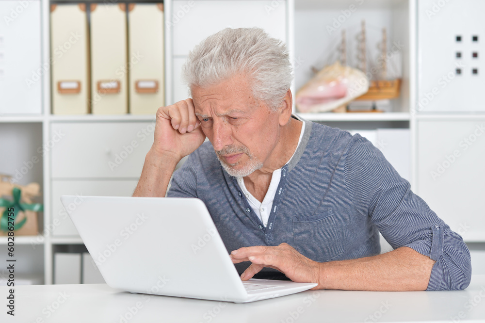 Thoughtful old man with laptop at home Thoughtful old man with laptop at home
