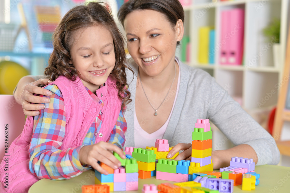 little girl and her mother playing with colorful plastic blocks little girl and her mother playing with colorful plastic blocks