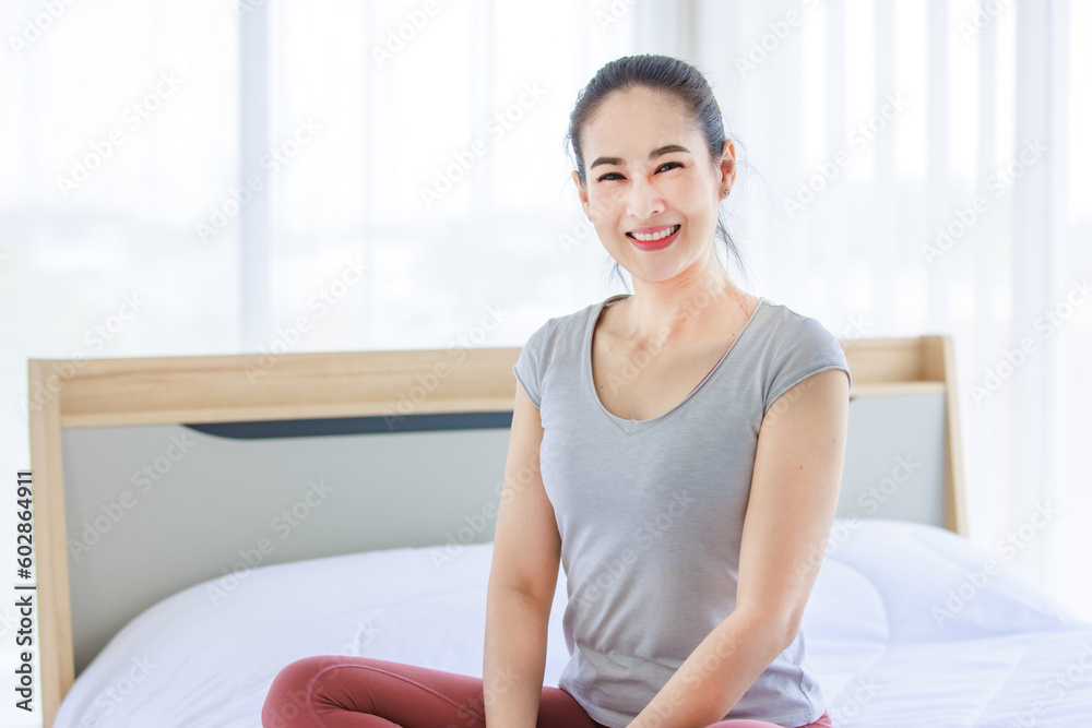 Portrait shot of Asian beautiful healthy fit slim sexy female sporty athlete model in sportswear and leggings sitting smiling look at camera on bed in bedroom morning ready for workout exercise Portrait shot of Asian beautiful healthy fit slim sexy female sporty athlete model in sportswear and leggings sitting smiling look at camera on bed in bedroom morning ready for workout exercise