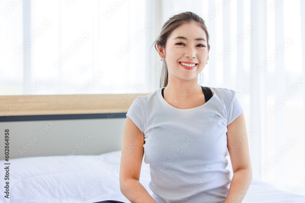 Portrait shot of Asian beautiful healthy fit slim sexy female sporty athlete model in sportswear and leggings sitting smiling look at camera on bed in bedroom morning ready for workout exercise Portrait shot of Asian beautiful healthy fit slim sexy female sporty athlete model in sportswear and leggings sitting smiling look at camera on bed in bedroom morning ready for workout exercise