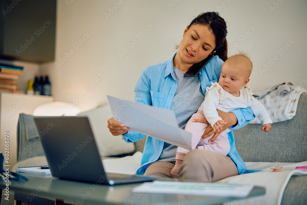 Obraz premium Multitasking mother with baby working at home.