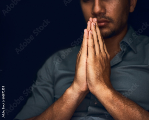 Praying, worship and hope with hands of man for religion, spirituality and faith. Focus, thinking and peace with closeup of person and mockup space on dark background for belief, prayer and gratitude © Crystal May Gaybba/peopleimages.com
