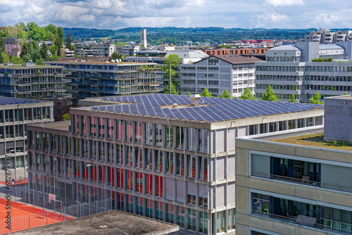Aerial view of rooftops with solar panels at City of Zürich district Oerlikon on a blue cloudy spring day. Photo taken May 12th, 2023, Zurich, Switzerland.