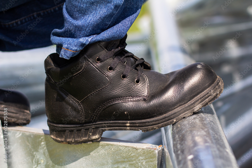 Wear safety shoes to ensure safety at work. construction workers wear safety shoes. People with