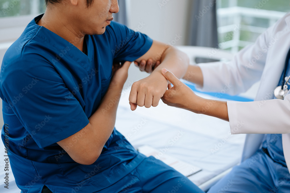 Physiotherapist Helping Patient While Stretching His Leg in bed in clinic .