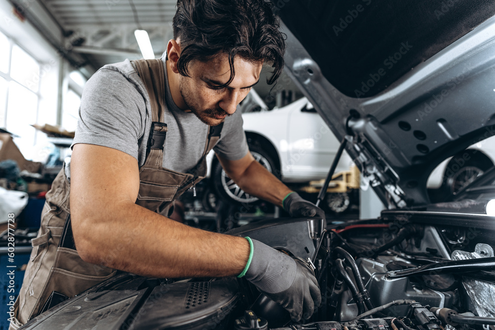 Mechanic examining car in auto car repair service center Mechanic examining car in auto car repair service center