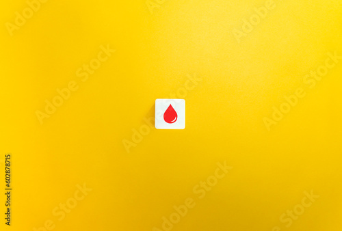 Blood group Concept. Blood drop on Letter Tile on Yellow Background. Minimal Aesthetics.