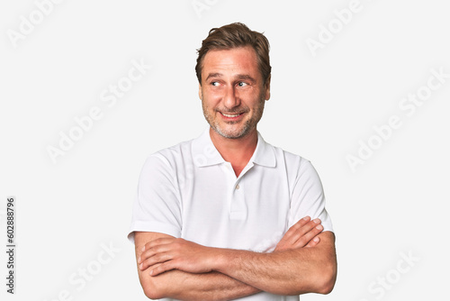 A middle-aged man isolated smiling confident with crossed arms. © Asier