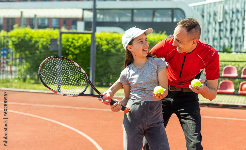 Active family playing tennis on court