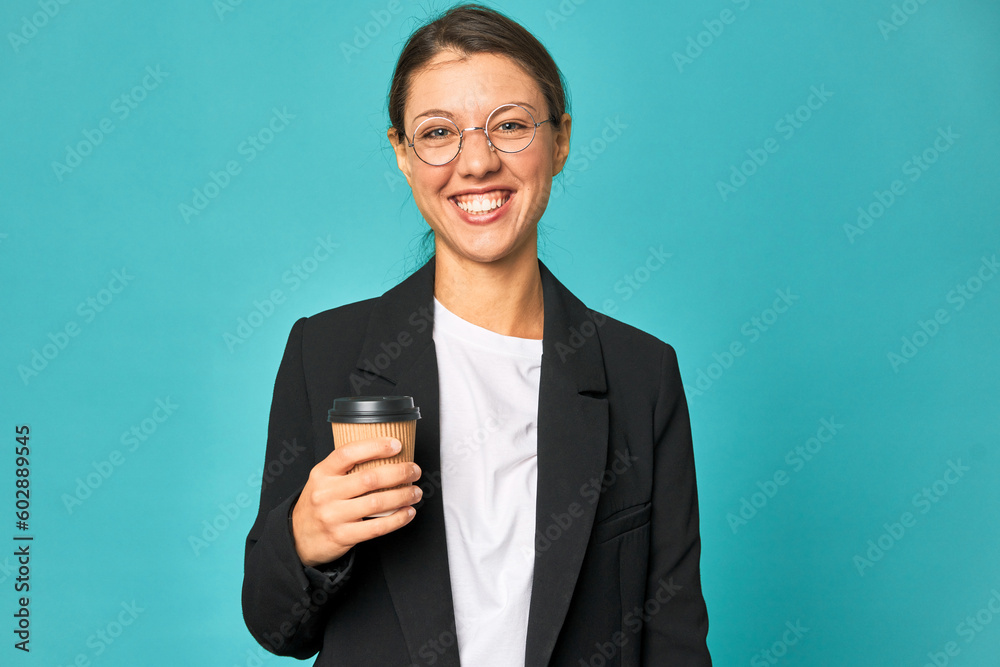 A young caucasian business woman holds a takeaway coffee happy, smiling and cheerful. A young caucasian business woman holds a takeaway coffee happy, smiling and cheerful.