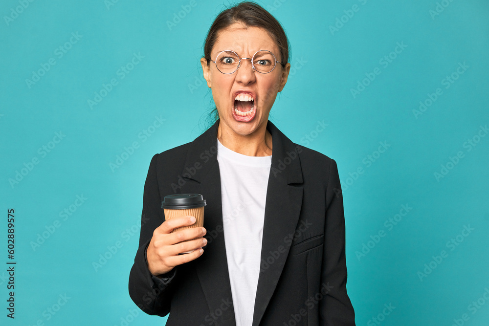 A young caucasian business woman holds a takeaway coffee screaming very angry and aggressive. A young caucasian business woman holds a takeaway coffee screaming very angry and aggressive.