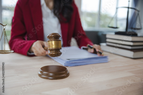 woman in red suit Lawyers signing documents at the office Lawyer consultant, justice and law, attorney, court judge, concept. photo