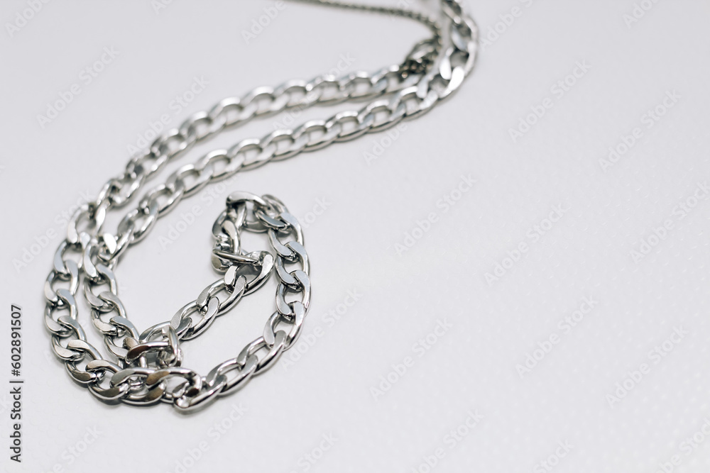 Different silver metal chains on a light background. Different silver metal chains on a light background.