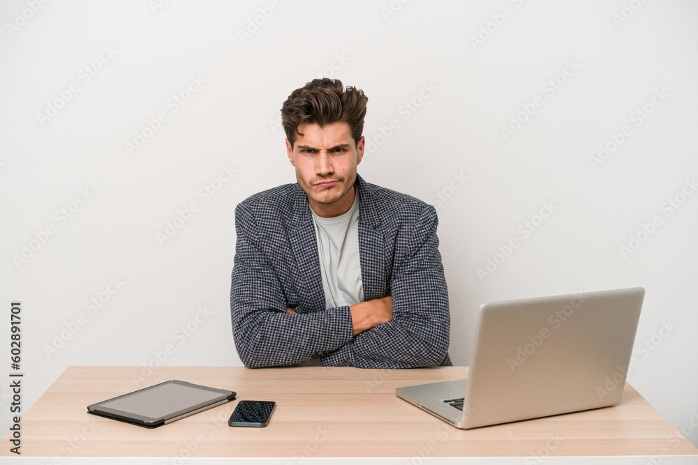 Young entrepreneur man working with a laptop isolated frowning face in displeasure, keeps arms folded. Young entrepreneur man working with a laptop isolated frowning face in displeasure, keeps arms folded.