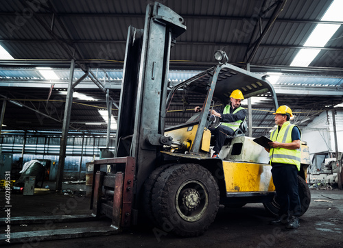 Industrial worker driving a forklift in the factory. Engineer is working and maintaining in the warehouse. © NewSaetiew