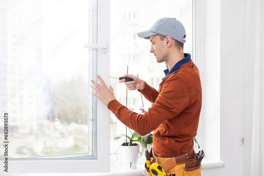 Construction worker installing window in house Construction worker installing window in house