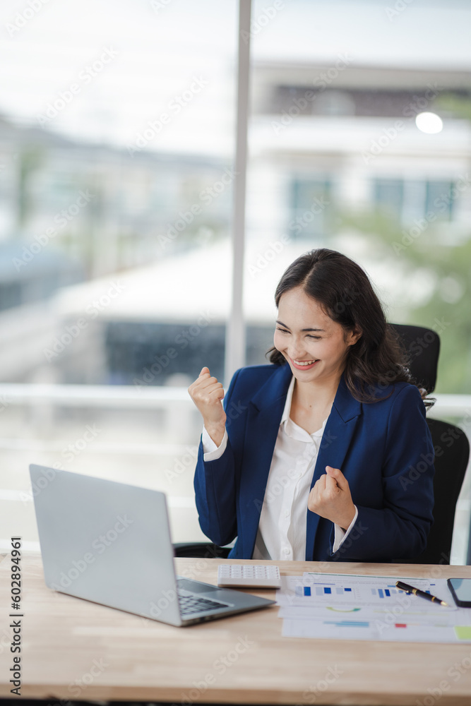happy young woman excited at work Successful Asian businesswoman with laptop smartphone at work. happy young woman excited at work Successful Asian businesswoman with laptop smartphone at work.