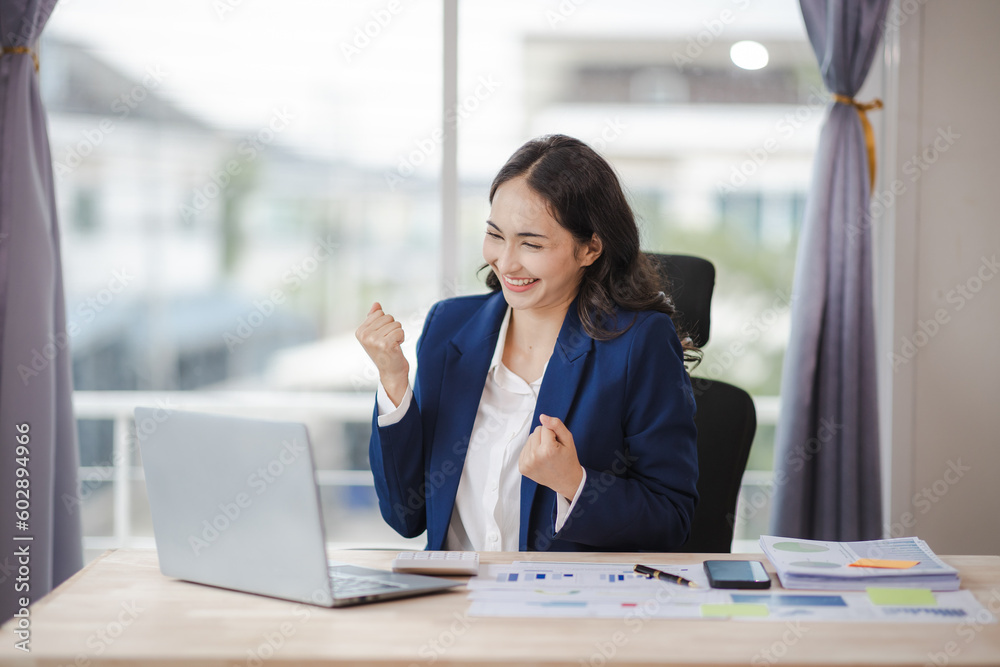 happy young woman excited at work Successful Asian businesswoman with laptop smartphone at work. happy young woman excited at work Successful Asian businesswoman with laptop smartphone at work.