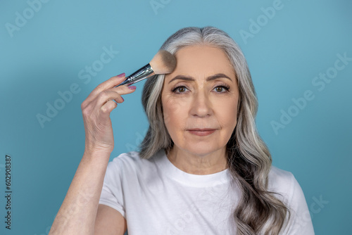 Beautiful senior woman with face brushes