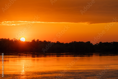 Leinwand Poster Golden sunset over a river or lake