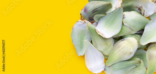 Fresh artichoke petals on yellow background
