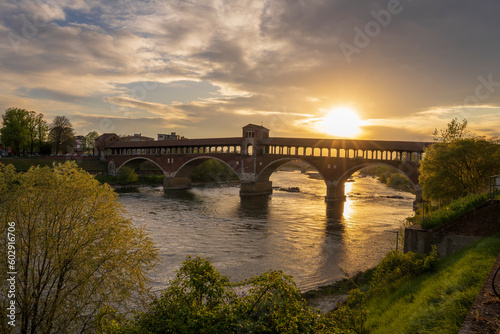 Ponte Coperto (covered bridge) over Ticino river in Pavia at sunset, Lombardy, italy.